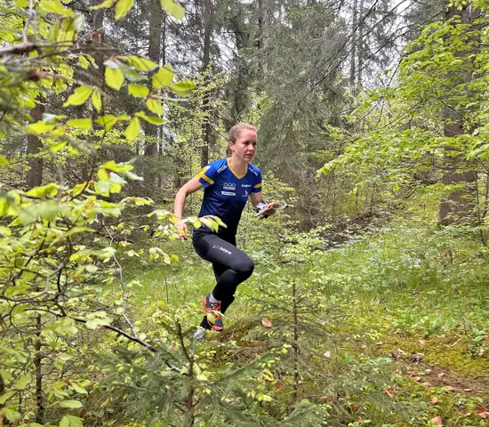 Lisa Risby springer genom grönskande skog vid landslagsläger i Schweiz.