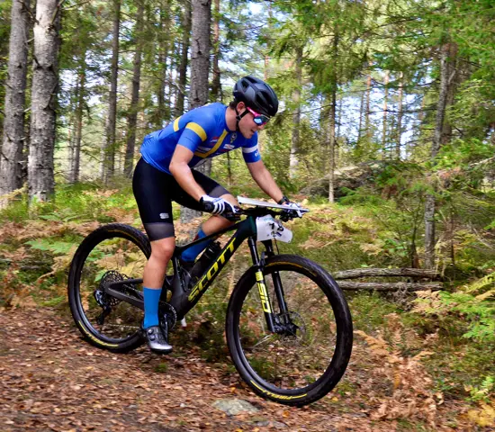 Rasmus Nordgren cyklar på en stig genom skogen i Haninge.